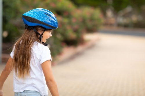 child  with helmet from behind with blurred background - Australian Stock Image