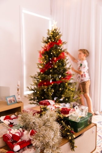 child working to decorate the Christmas Tree focus on decorations