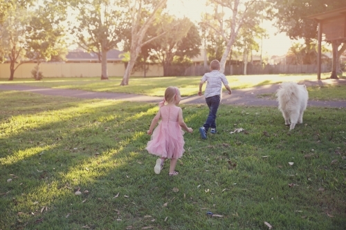 Children and dog playing in the park - Australian Stock Image