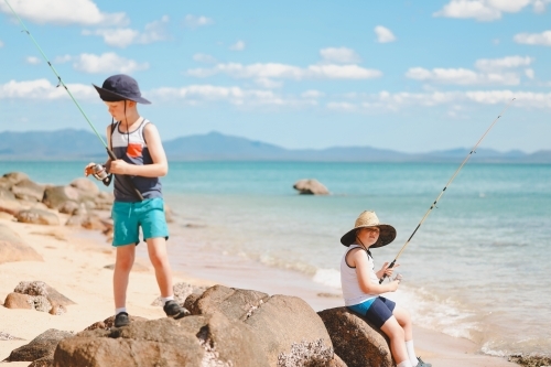 Children fishing on the beach at Cape Gloucester in the Whitsundays - Australian Stock Image