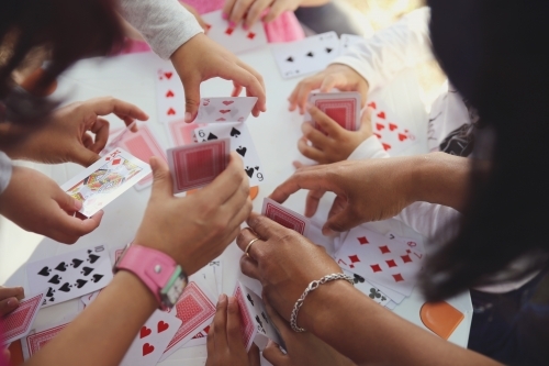 Children having fun with playing card game - Australian Stock Image