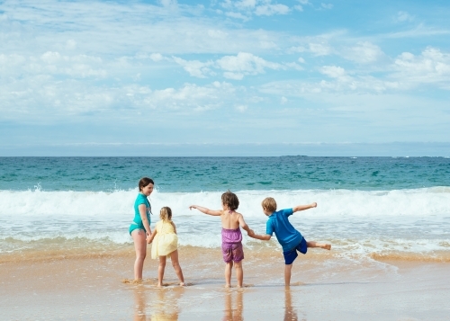 Children holding hands at the beach - Australian Stock Image
