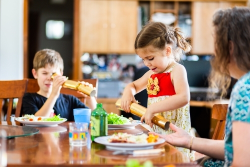 Children playing with Christmas crackers at Christmas lunch - Australian Stock Image