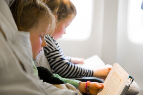 Children reading books on a plane