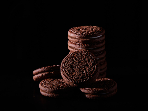 Chocolate cream biscuits on black background - Australian Stock Image