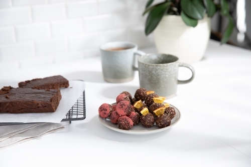 Chocolate protein balls on a white kitchen bench - Australian Stock Image