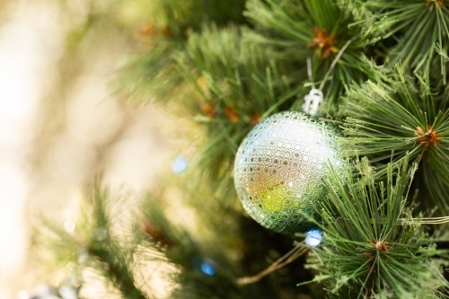Christmas bokeh copy space beside green bauble on tree - Australian Stock Image