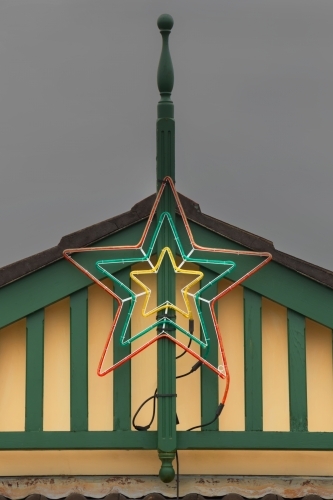 Christmas star decoration neon light on house gable roof