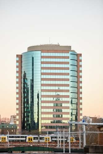 City building on dusk with train passing by - Australian Stock Image
