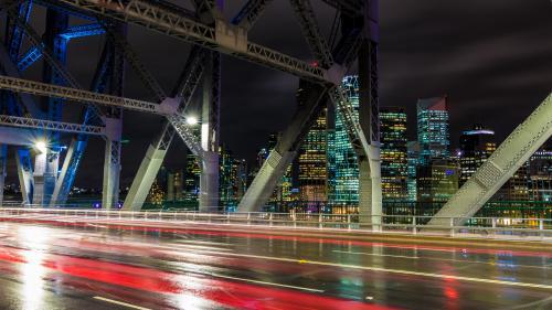 City skyline from bridge at night with traffic light trails