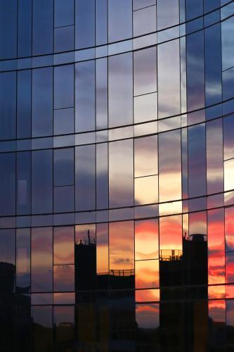 City sunset reflections in windows of tall building