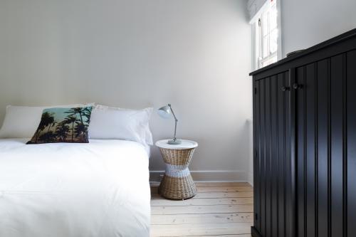 Clean white guest bedroom in modern designer apartment - Australian Stock Image