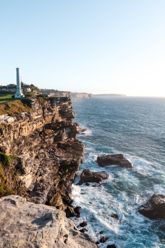 Cliff face and crashing waves at sunrise - Australian Stock Image