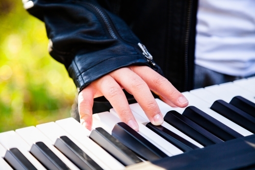 Close up detail of boy playing keyboard keys - Australian Stock Image