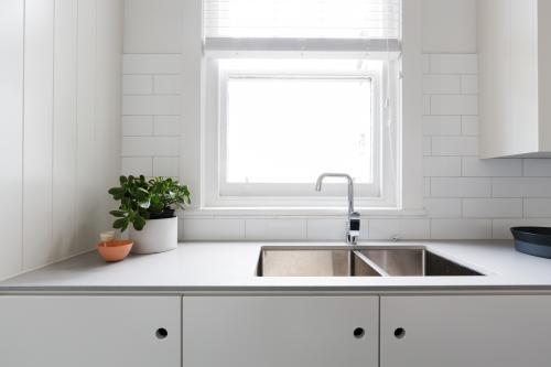 Close up details of contemporary white apartment kitchen with subway tiles