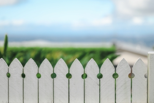 Close up image of white picket fence with beach background - Australian Stock Image