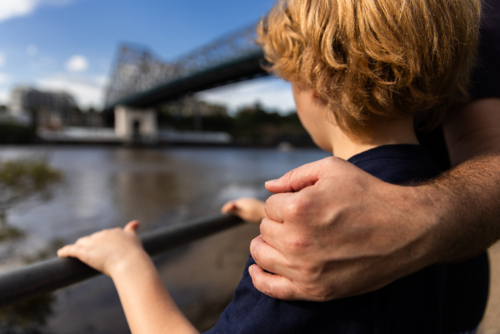 close up of a father's hand hugging his son - Australian Stock Image