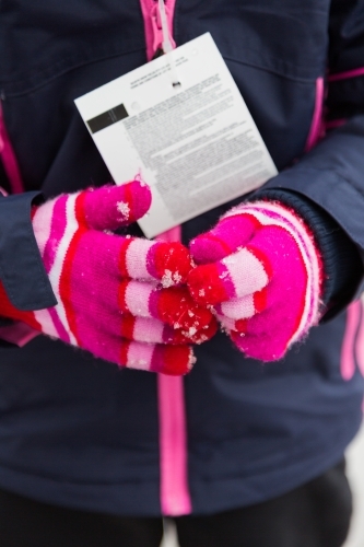 Close up of a pair of pink gloves at the snow