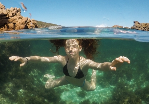 Close up of a teenage girl underwater in an ocean rock pool - Australian Stock Image