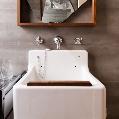 Close up of a vintage style bathroom sink with wood detail