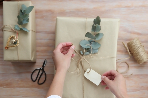 Close up of a womans' hands wrapping present - Australian Stock Image