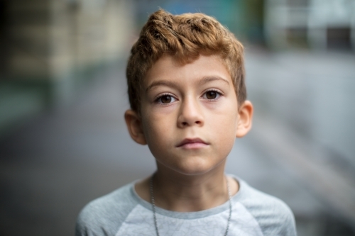 Close-up of a young boy with curly hair - Australian Stock Image