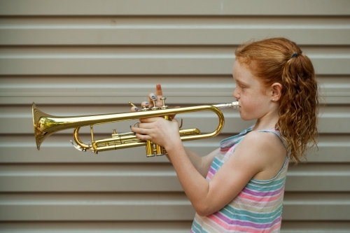 Close up of a young girl playing a trumpet - Australian Stock Image