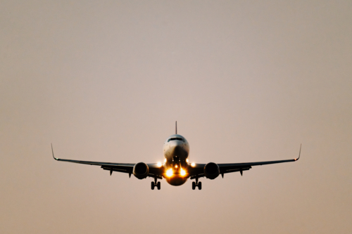 Close up of commercial airplane ready to land on the runway at sunset - Australian Stock Image