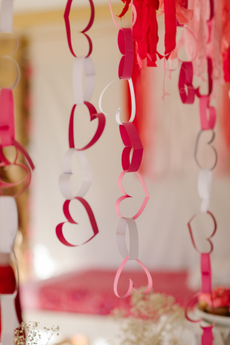 Close-up of hanging handmade paper chains shaped like hearts in shades of pink, red, and white - Australian Stock Image
