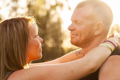Close up of happy couple looking at one another in beautiful light - Australian Stock Image
