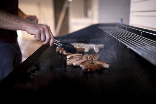 Close up of man cooking sausages on a barbeque - Australian Stock Image