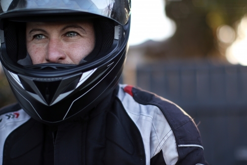 Close up of man wearing a motorbike helmet - Australian Stock Image