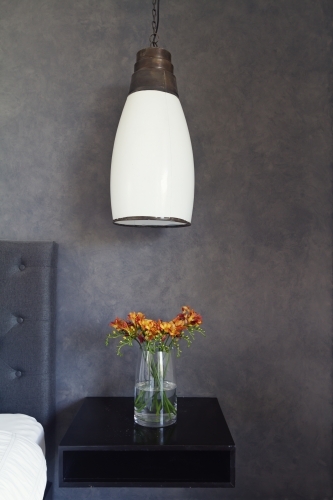 Close up of pendant light and flowers on bed side table