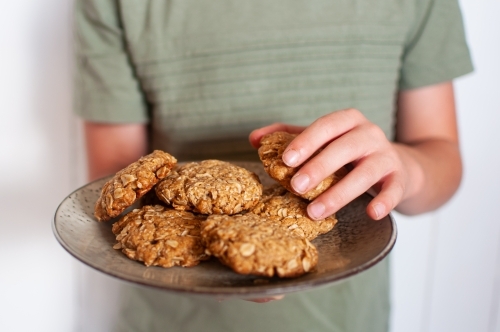 Close up of plate of cookies held by child