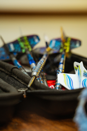 Close-up of professional steel tip darts in black zippered case. - Australian Stock Image