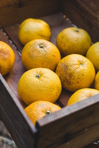 Close up of rustic timber box of orange citrus fruit - Australian Stock Image