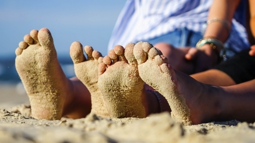 Close up of sandy feet on beach