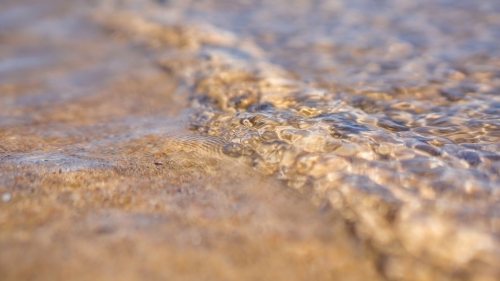 Close up of shallow water rippling over the sand