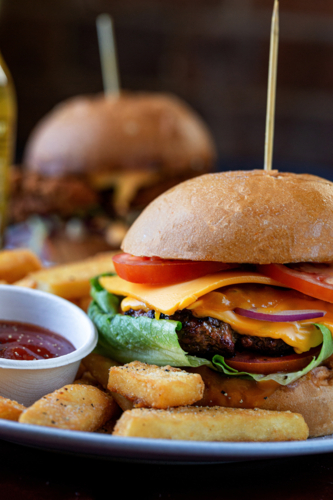 Close up of tacked cheeseburger served on a white plate - Australian Stock Image
