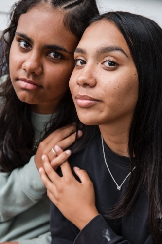 Close-up of two Aboriginal girls hugging - Australian Stock Image