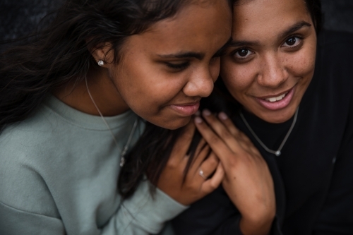 Close-up of two Aboriginal girls hugging - Australian Stock Image