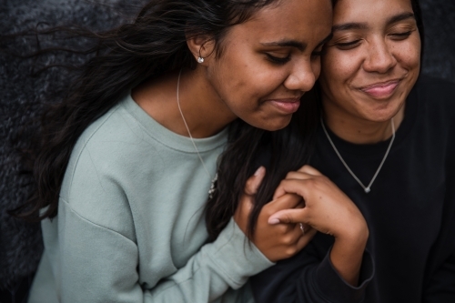 Close-up of two Aboriginal girls hugging - Australian Stock Image
