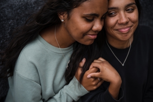 Close-up of two Aboriginal girls hugging - Australian Stock Image