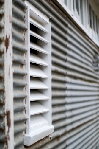 Close up of white timber louvre on corrugated iron shed - Australian Stock Image