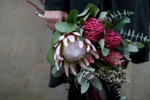 Close up of woman's hand holding a bouquet of native flowers