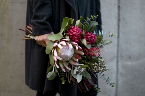 Close up of woman's hand holding a bouquet of native flowers - Australian Stock Image