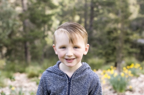 Close up of young boy in the bush smiling - Australian Stock Image