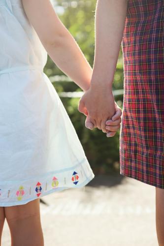 Close up of young girls hands being held - Australian Stock Image