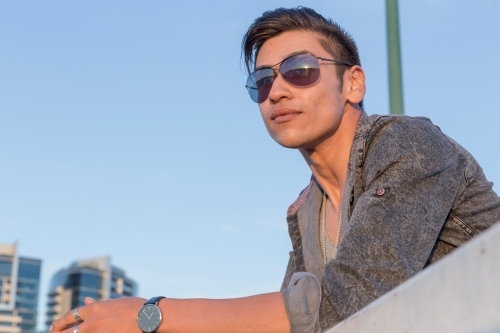 Close up of young latino male watching sunset - Australian Stock Image