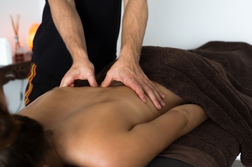 Close up of young woman back getting massage. Masseuse palms sports massage - Australian Stock Image